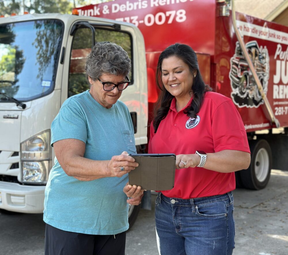 Junk removal professional holding a tablet explaining the cost of deck removal services